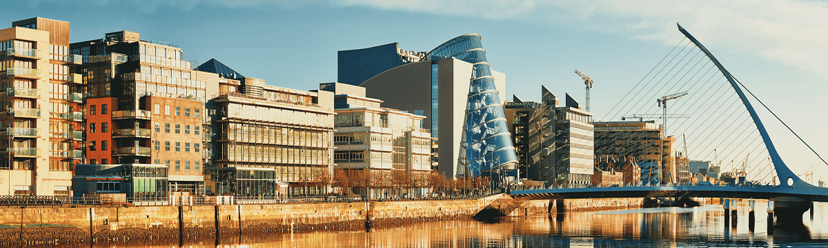 Dublin quayside with the Samuel Beckett Bridge and Convention Centre reflected in the River Liffey at sunset